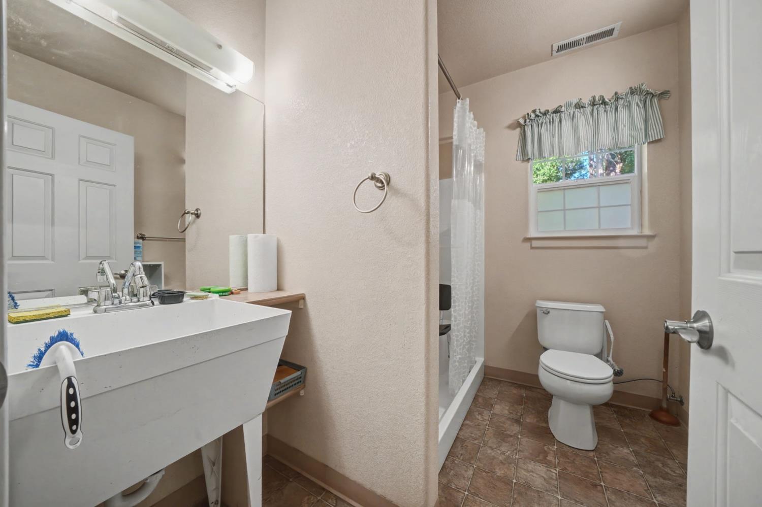 16111 Pioneer Creek Road Pioneer, CA 95666 - Photo 41 of 59 a bathroom with a sink toilet a mirror and shower