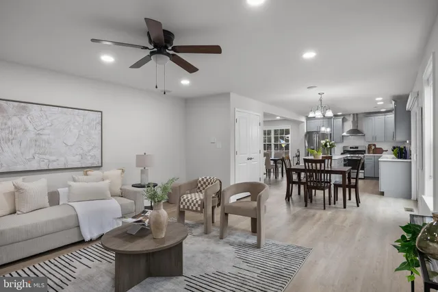a living room with furniture and a dining table with kitchen view