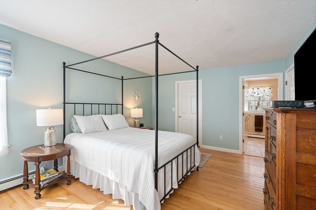 13 Jonathans Way Upton, MA 01568 - Photo 18 of 36 a bedroom with a bed a mirror on dresser and a wooden floor