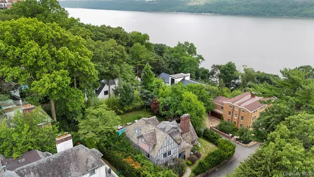 an aerial view of a house with a yard and lake view