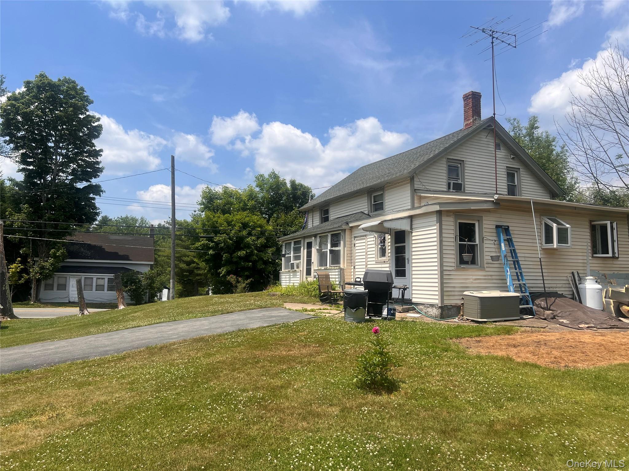 279 Cold Spring Road Monticello, NY 12701 - Photo 4 of 32 Rear view of house with a lawn, a chimney, and a patio