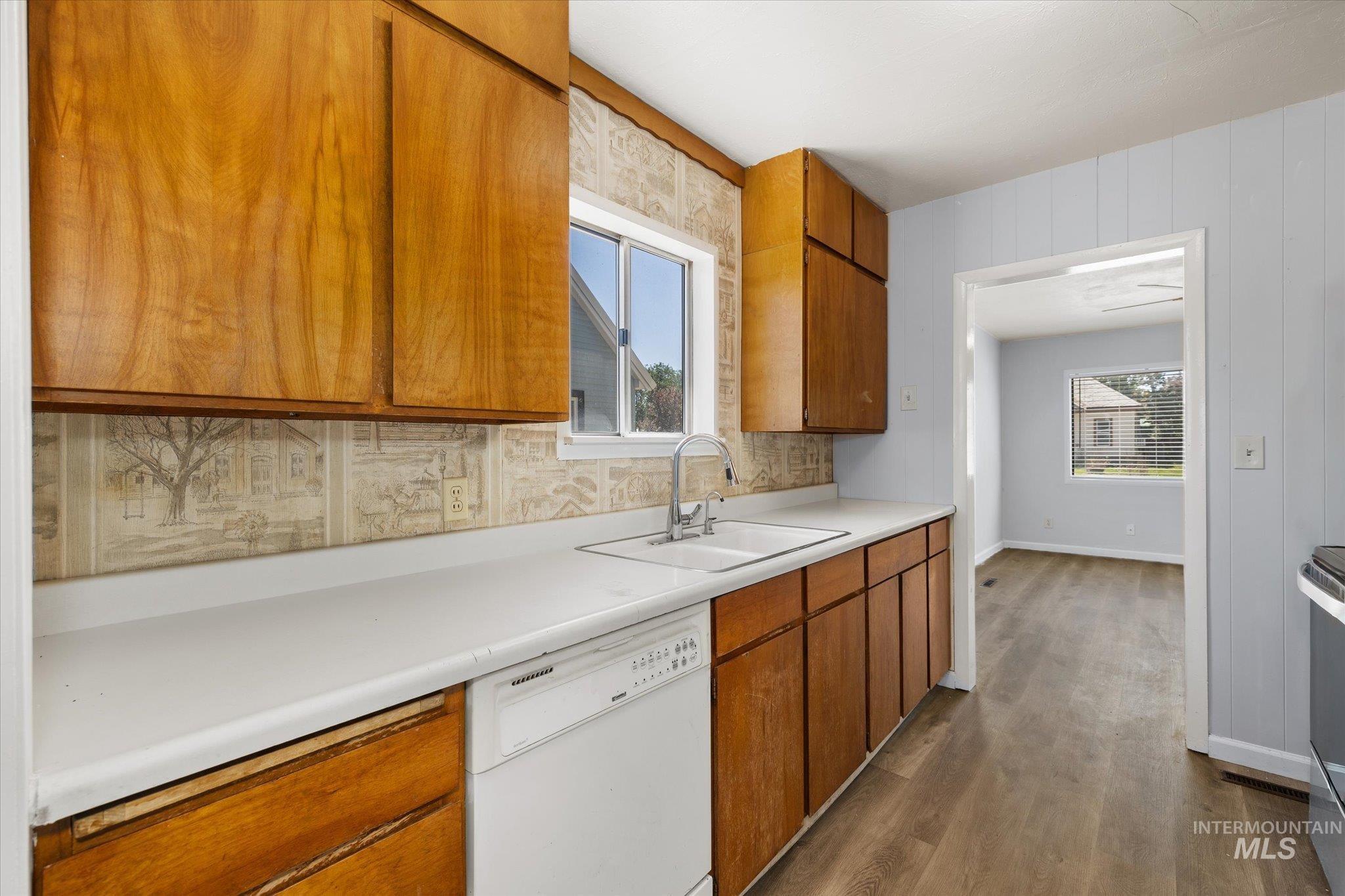 918 West 3rd Street Weiser, ID 83672 - Photo 16 of 36 Kitchen featuring wood cabinetry, white countertops, a double basin sink with a chrome faucet, and a built-in dishwasher