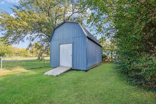 a view of backyard with wooden fence and large trees