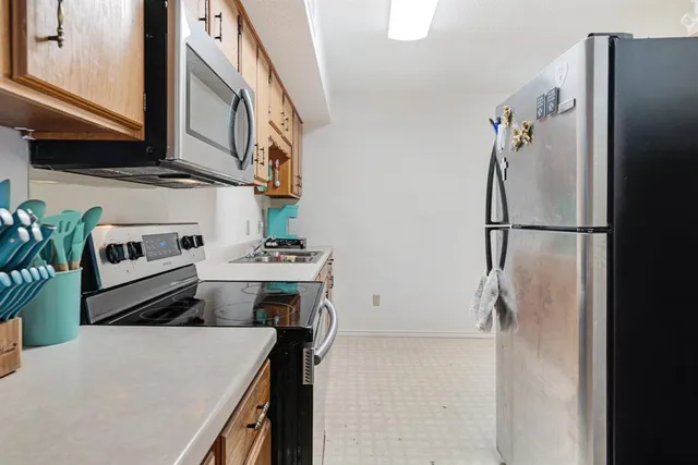 a kitchen with stainless steel appliances a refrigerator and a stove top oven