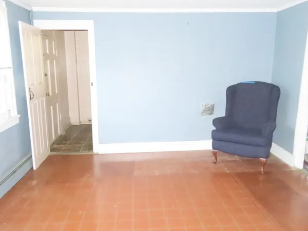 a view of a hallway with wooden floor and a bathroom
