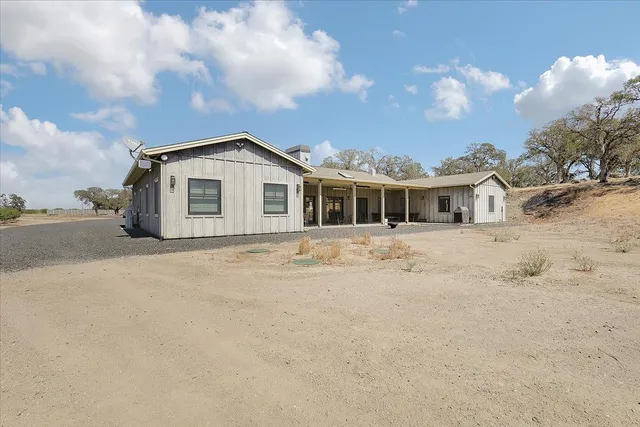 a kitchen with stainless steel appliances granite countertop a table chairs sink and cabinets