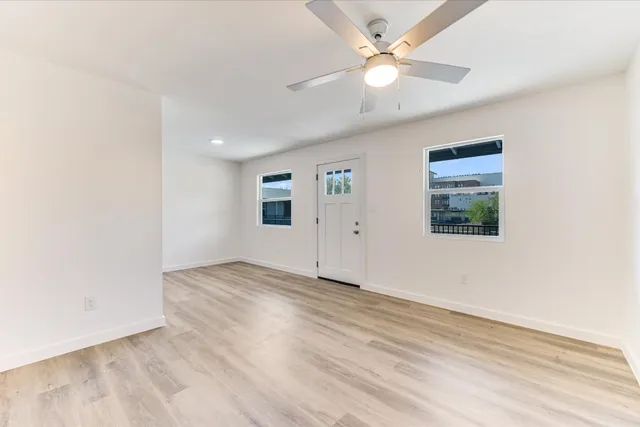 an empty room with fan and windows