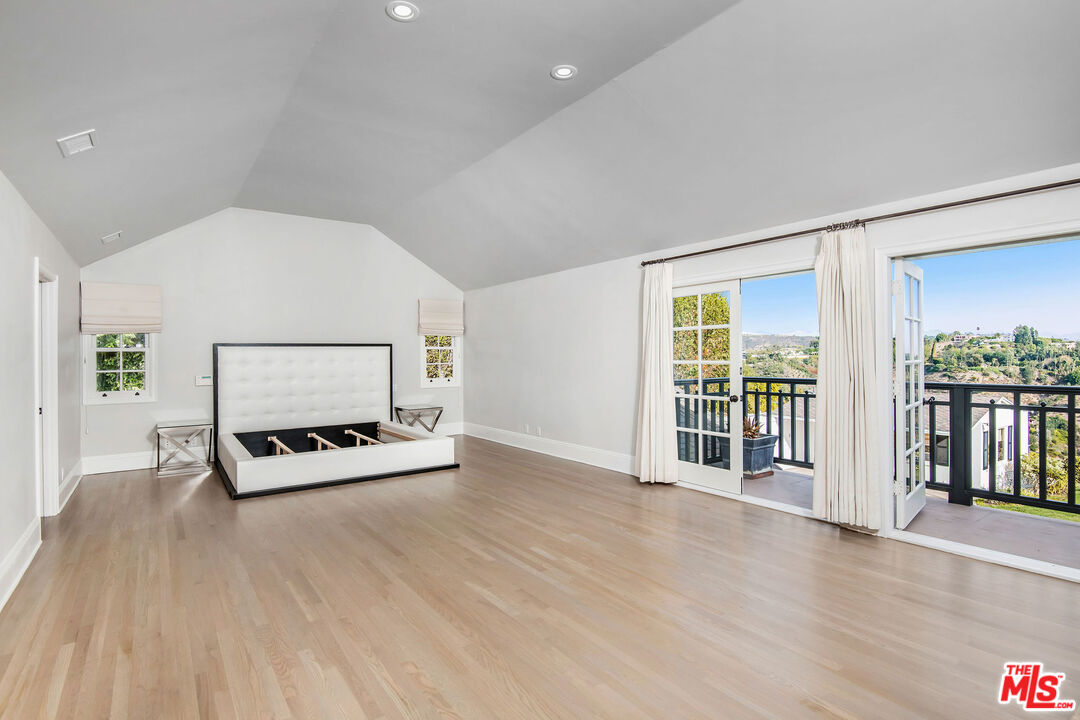 1110 Stradella Road Los Angeles, CA 90077 - Photo 11 of 26 a living room with furniture a flat screen tv and floor to ceiling window