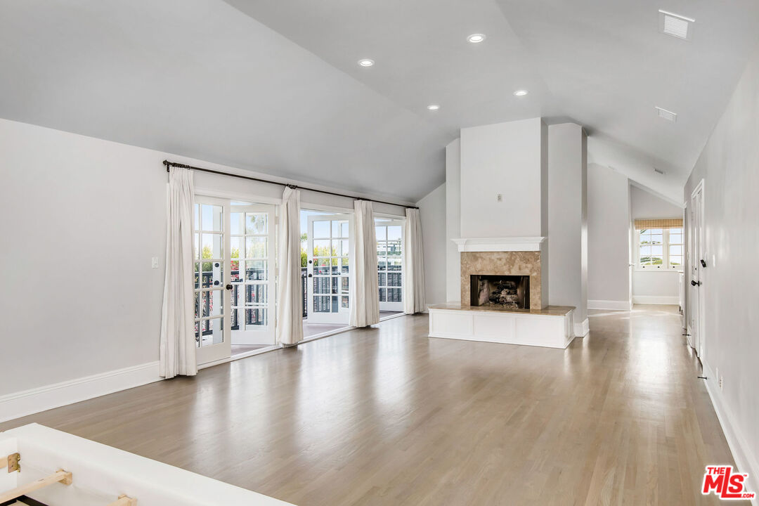 1110 Stradella Road Los Angeles, CA 90077 - Photo 12 of 26 a view of an empty room with wooden floor and a fireplace