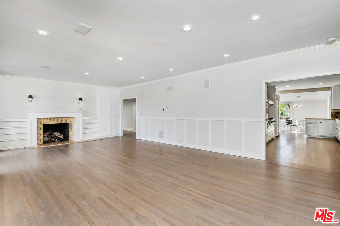 1110 Stradella Road Los Angeles, CA 90077 - Photo 2 of 26 a view of an empty room with wooden floor fireplace and a window