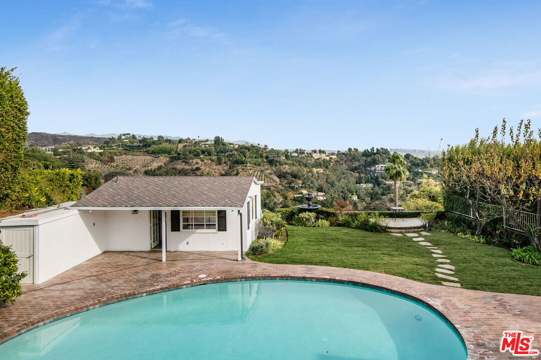 1110 Stradella Road Los Angeles, CA 90077 - Photo 22 of 26 a view of a house with a big yard and palm trees