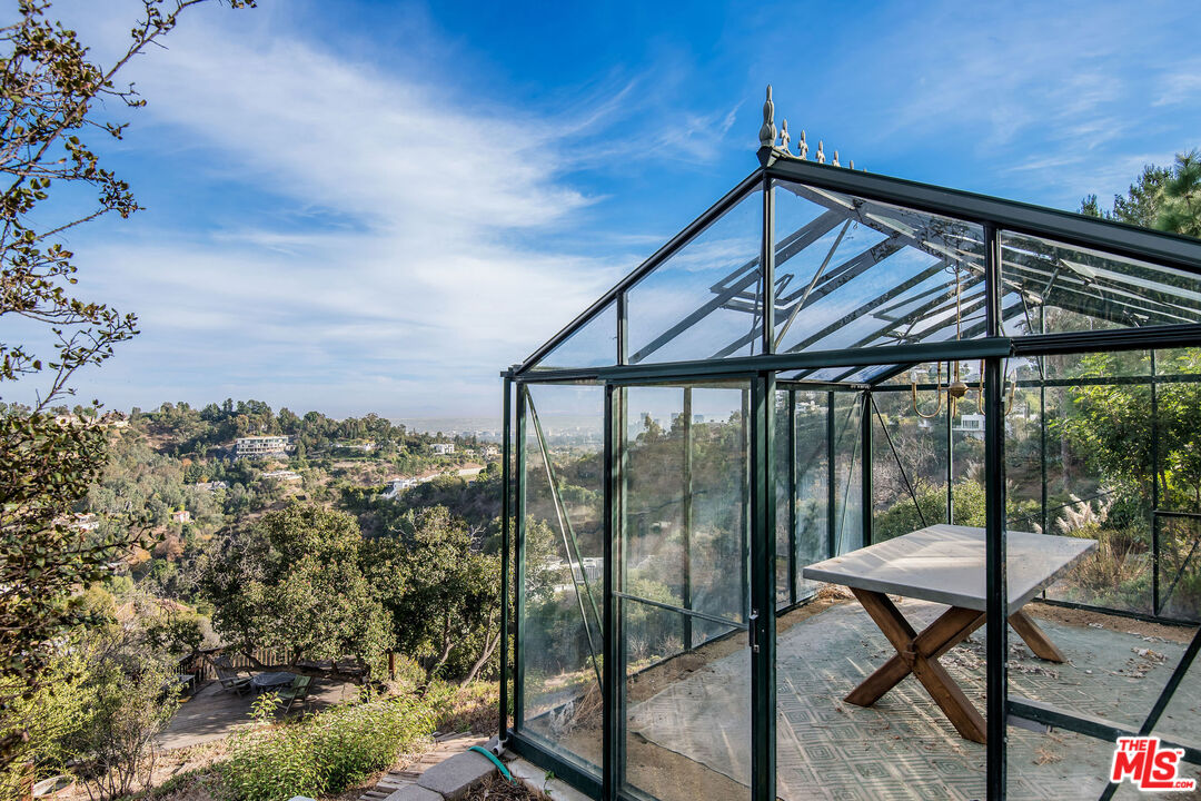 1110 Stradella Road Los Angeles, CA 90077 - Photo 23 of 26 a patio with table and chairs and potted plants
