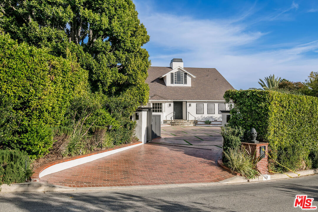 1110 Stradella Road Los Angeles, CA 90077 - Photo 25 of 26 a front view of a house with a yard