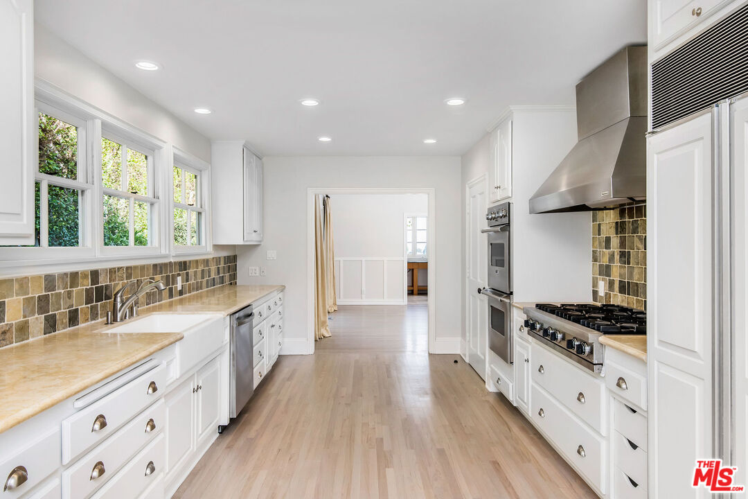 1110 Stradella Road Los Angeles, CA 90077 - Photo 6 of 26 a large kitchen with stainless steel appliances granite countertop a lot of counter space and wooden floors