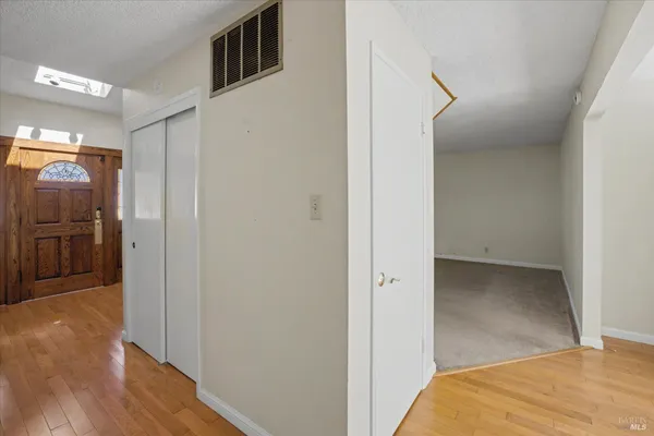 an empty room with windows and fan