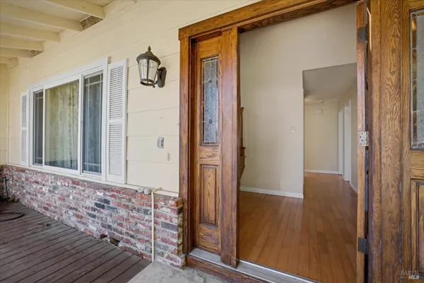 a view of a hallway with wooden floor and entryway