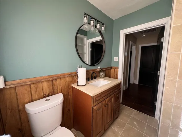 a bathroom with a toilet a sink and a mirror