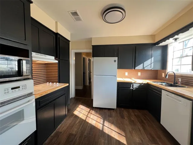 a kitchen with stainless steel appliances a refrigerator a sink a stove a microwave and cabinets