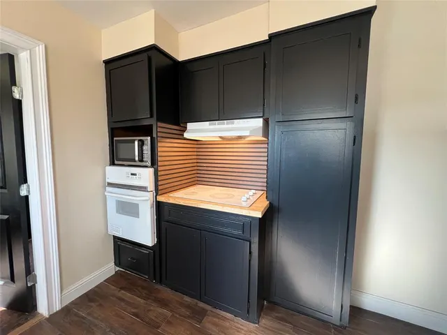 a kitchen with a refrigerator and white cabinets
