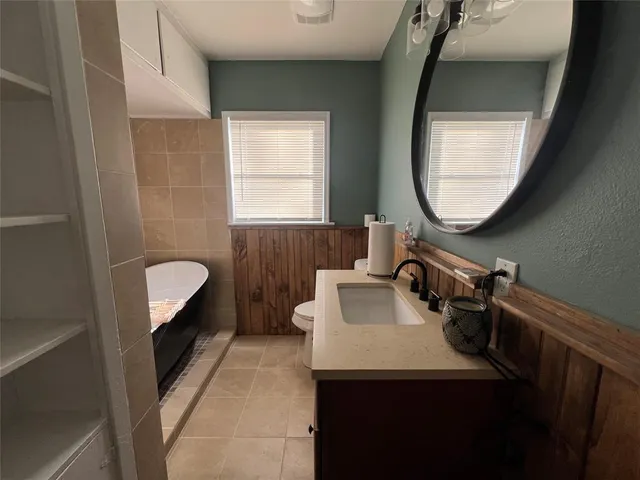 a bathroom with a sink a toilet and a mirror