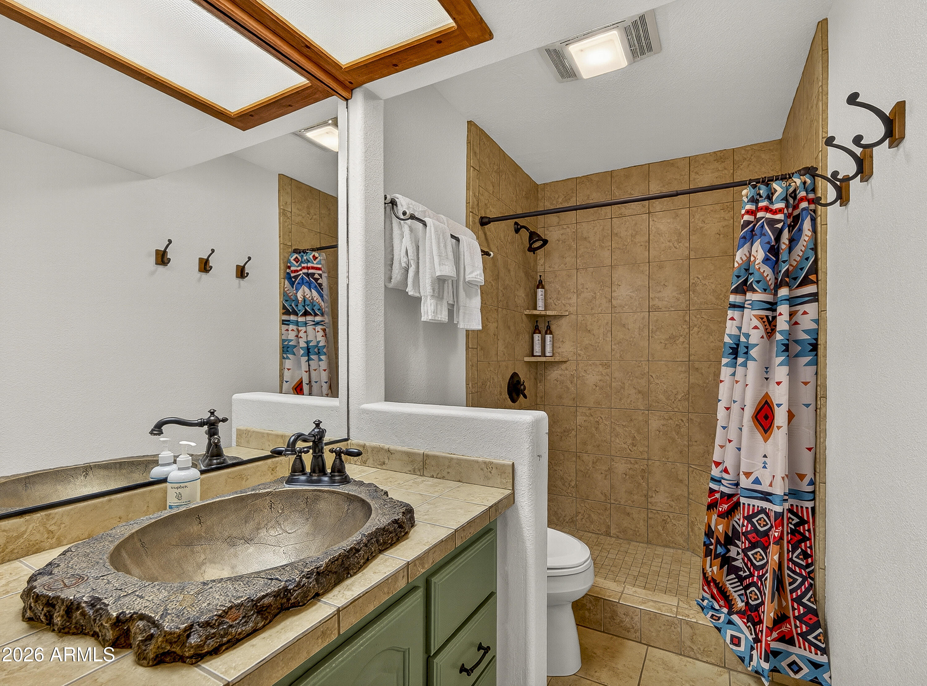65 Verde Valley School Road, Unit E3 Sedona, AZ 86351 - Photo 10 of 24 a bathroom with a granite countertop sink a toilet and shower curtain