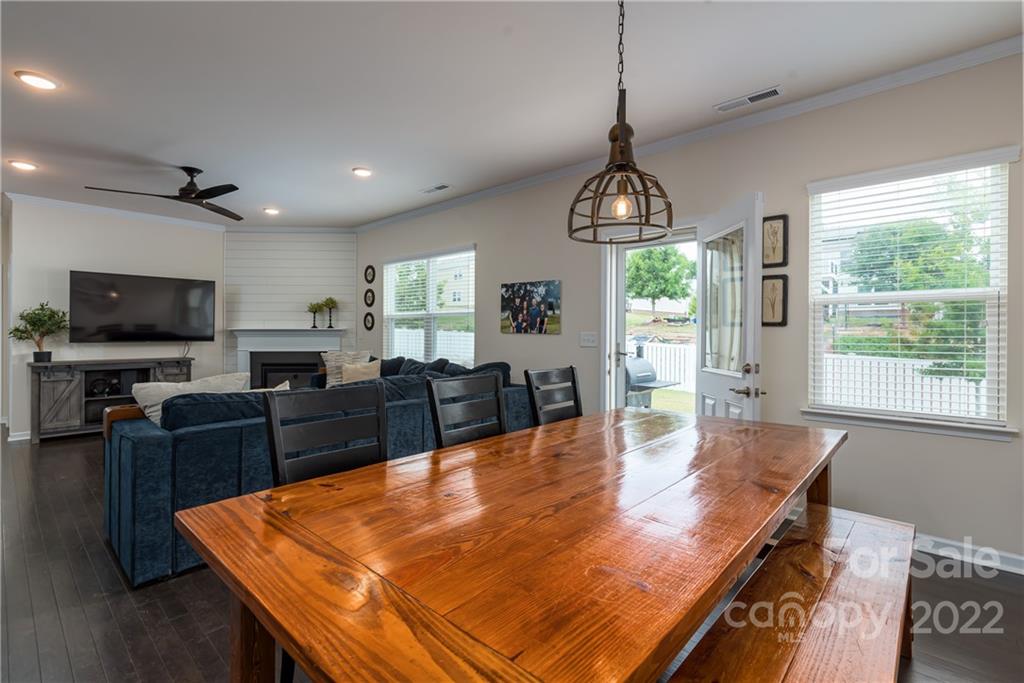 239 Keating Pl Drive Fort Mill, SC 29708 - Photo 11 of 33 a dining room with wooden floor a chandelier a wooden table and chairs