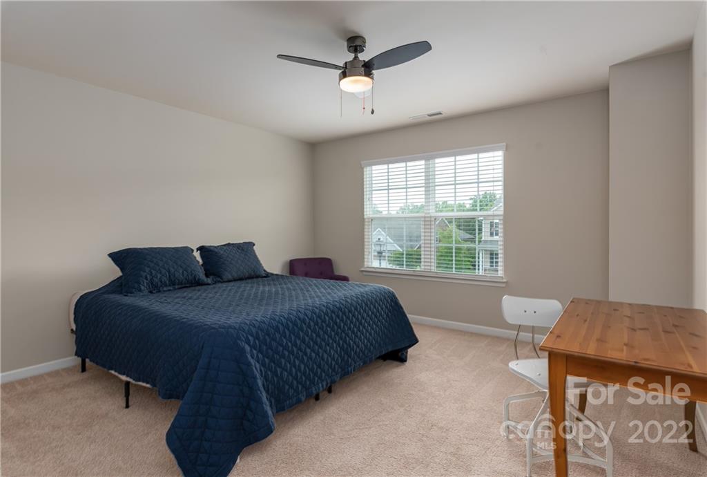 239 Keating Pl Drive Fort Mill, SC 29708 - Photo 24 of 33 a spacious bedroom with a bed and a table in it