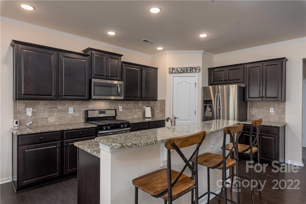239 Keating Pl Drive Fort Mill, SC 29708 - Photo 8 of 33 a kitchen with stainless steel appliances granite countertop a stove a sink a microwave a refrigerator and cabinets