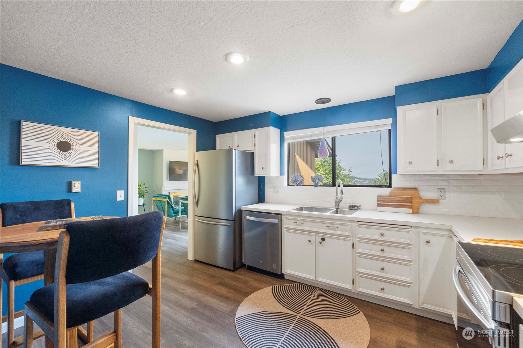 1633 Eagle Ridge Drive South, Unit A1 Renton, WA 98055 - Photo 2 of 35 a kitchen with a refrigerator a sink dishwasher with a dining table and chairs