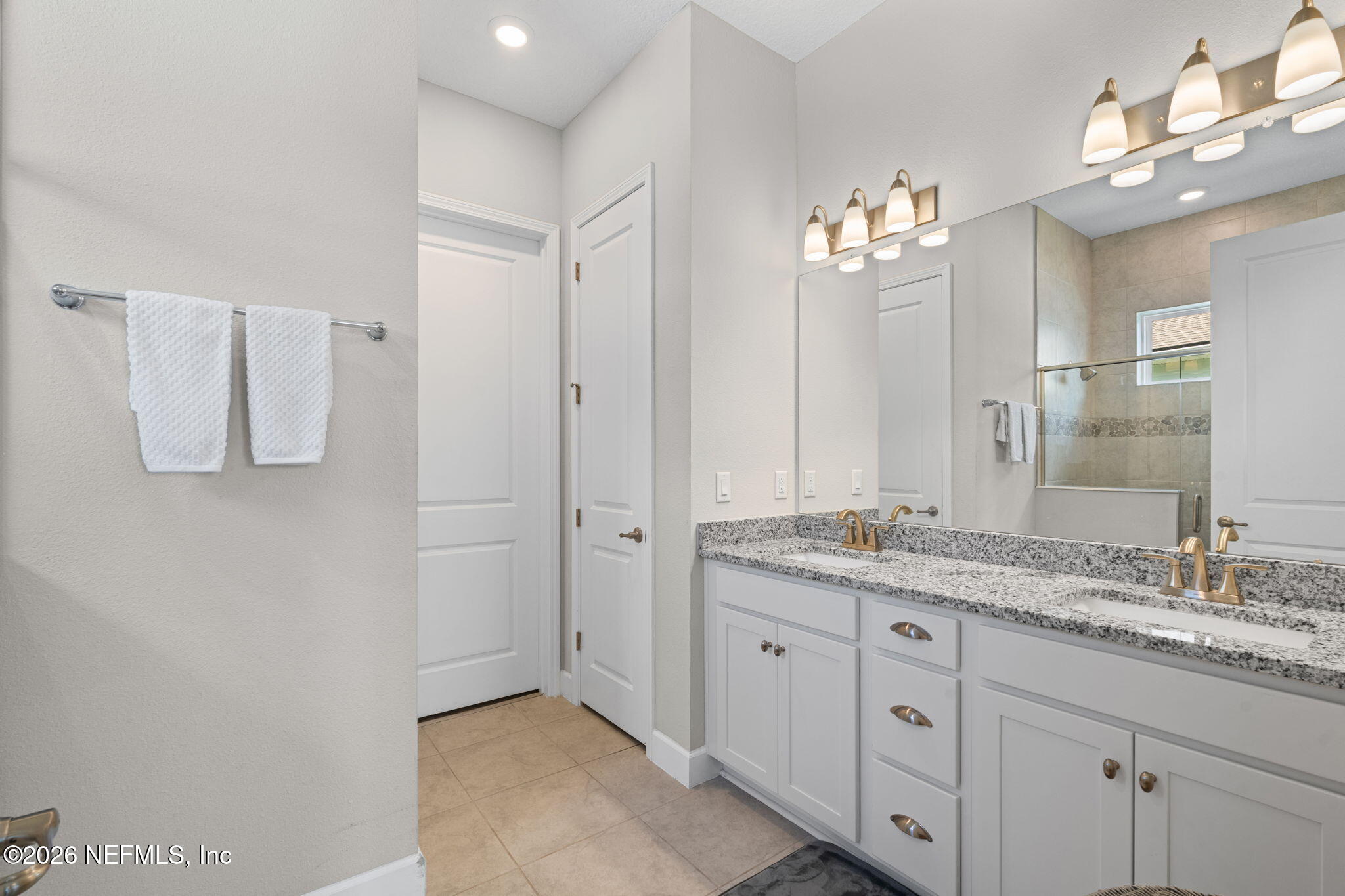 813 Rustic Mill Dr Street St. Augustine, FL 32092 - Photo 24 of 57 a bathroom with a granite countertop sink a mirror and a shower