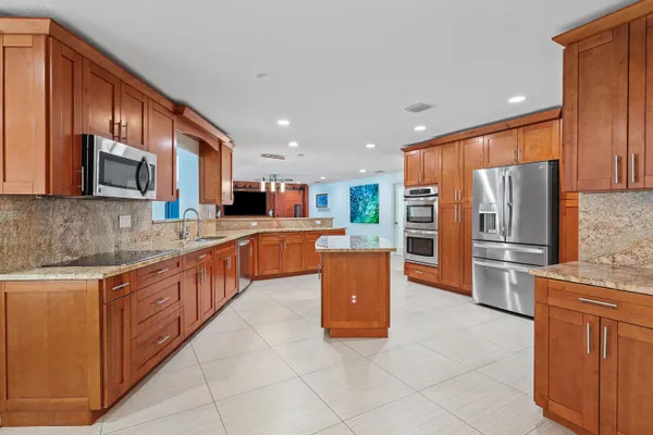 a kitchen with kitchen island granite countertop wooden cabinets and white appliances