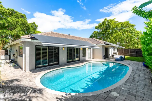 a view of a house with swimming pool and sitting area