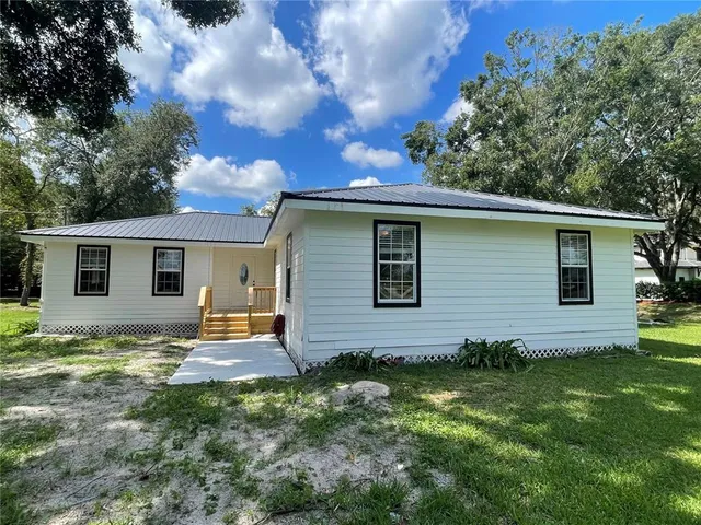 a backyard of a house with table and chairs