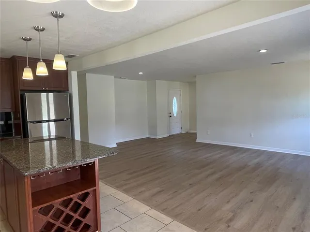 a view of a kitchen with a sink and dishwasher with wooden floor
