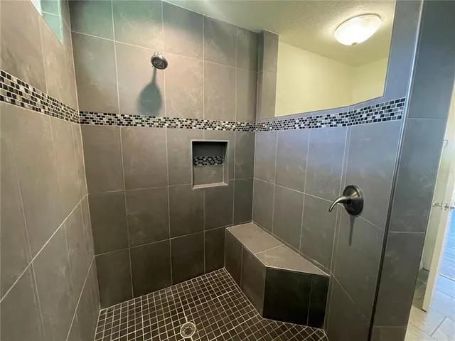 a bathroom with a sink a toilet a shower and a mirror