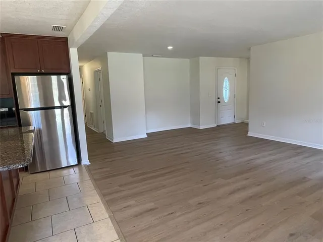 a view of kitchen with refrigerator and wooden floor
