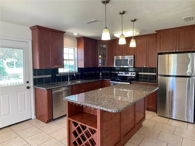 a kitchen with stainless steel appliances granite countertop a sink stove and refrigerator