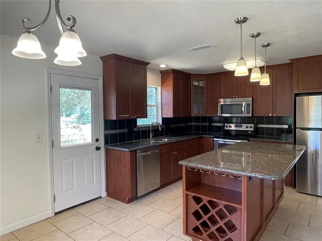 a kitchen with stainless steel appliances granite countertop a stove a sink a refrigerator and a granite counter tops