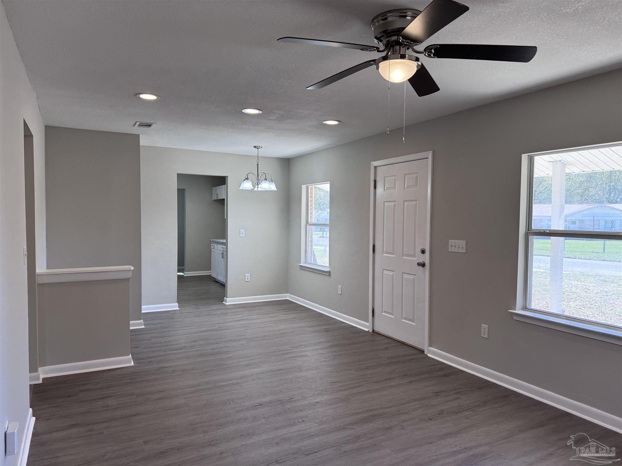 6426 Walnut Street Milton, FL 32570 - Photo 2 of 21 a view of an empty room with wooden floor and a window