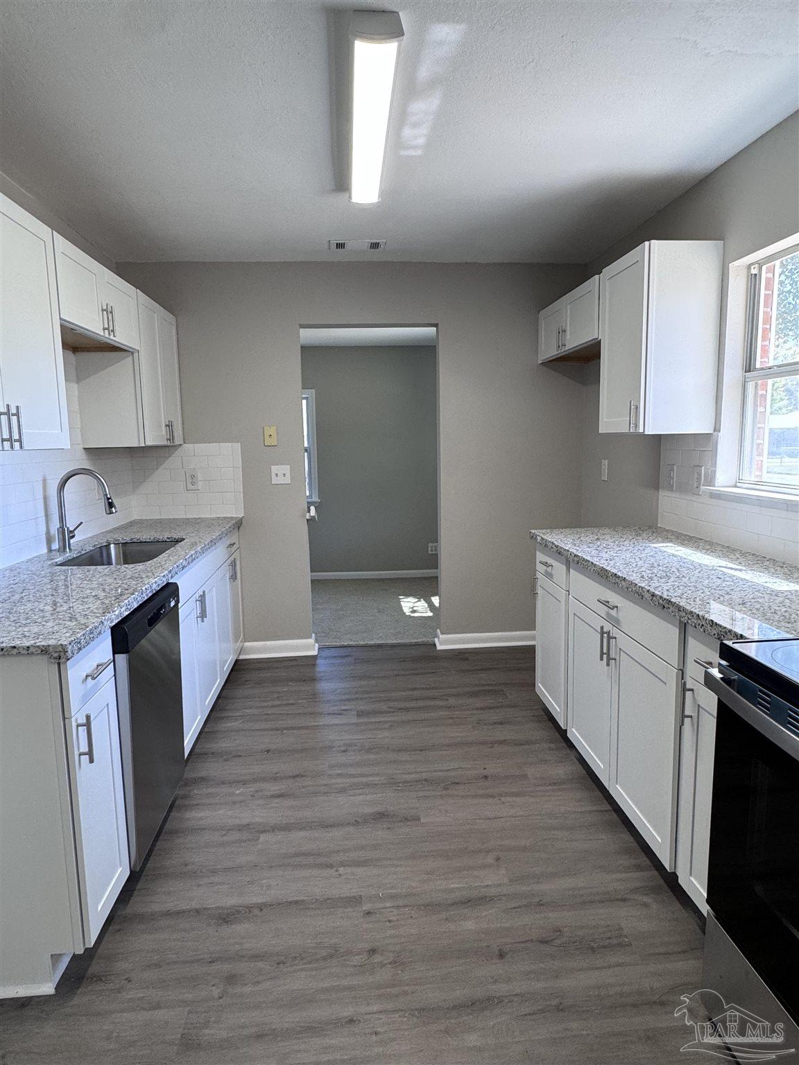 6426 Walnut Street Milton, FL 32570 - Photo 5 of 21 a large kitchen with a stove top oven