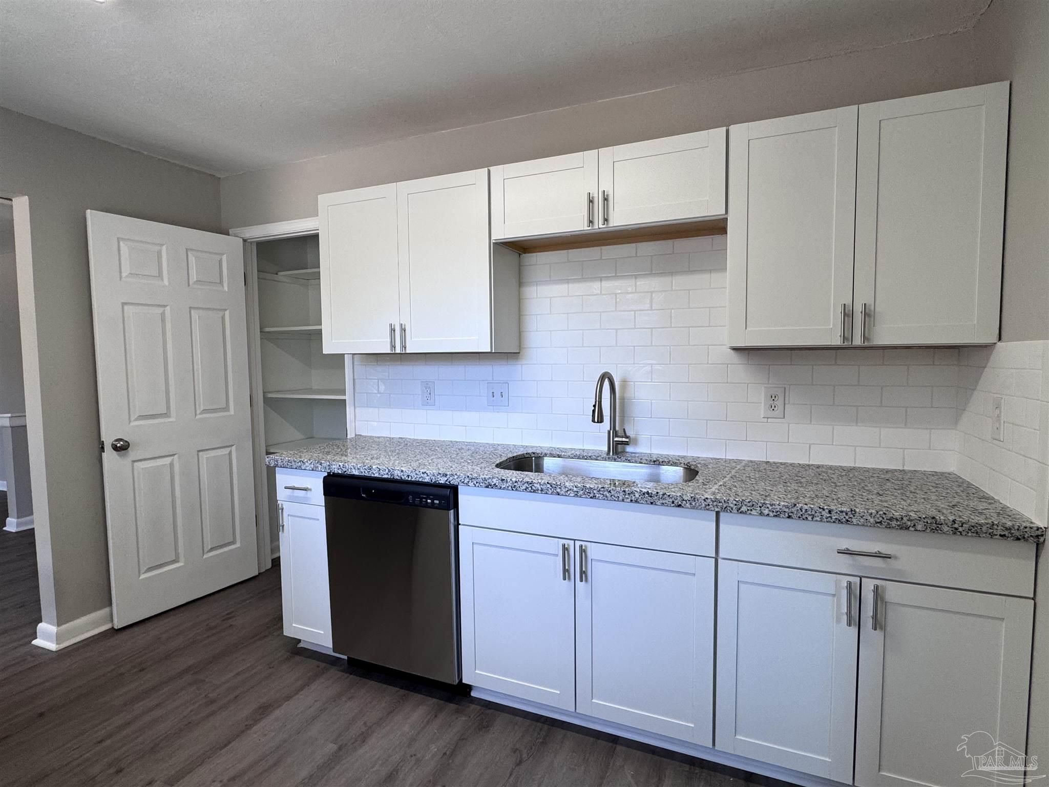 6426 Walnut Street Milton, FL 32570 - Photo 6 of 21 a kitchen with granite countertop cabinets and a wooden floor