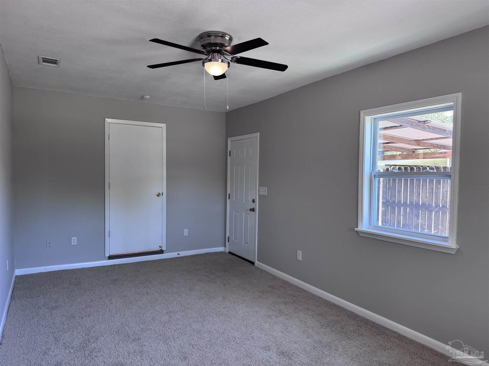 6426 Walnut Street Milton, FL 32570 - Photo 8 of 21 an empty room with windows and fan