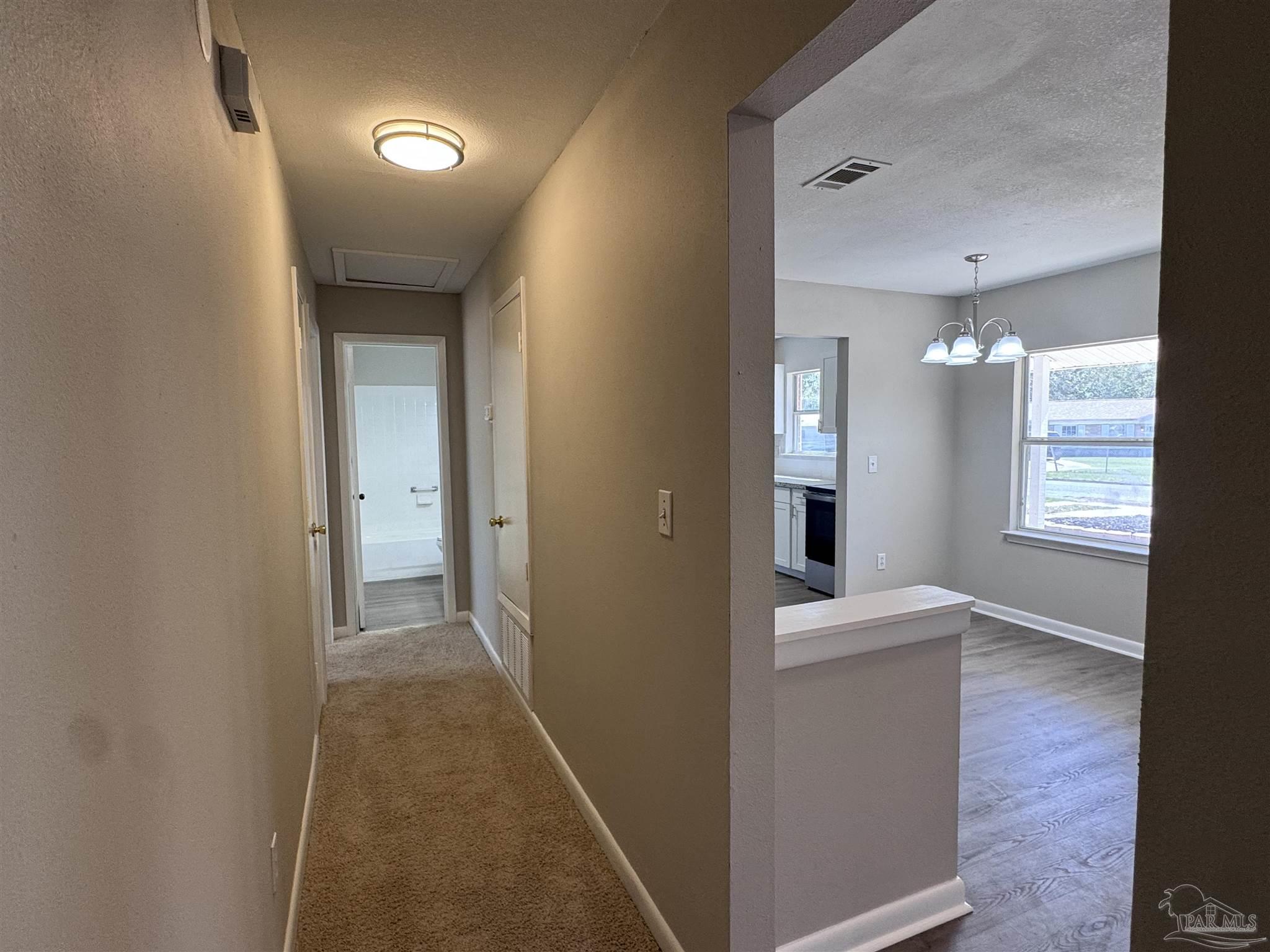 6426 Walnut Street Milton, FL 32570 - Photo 10 of 21 a view of a hallway with wooden floor and a living room