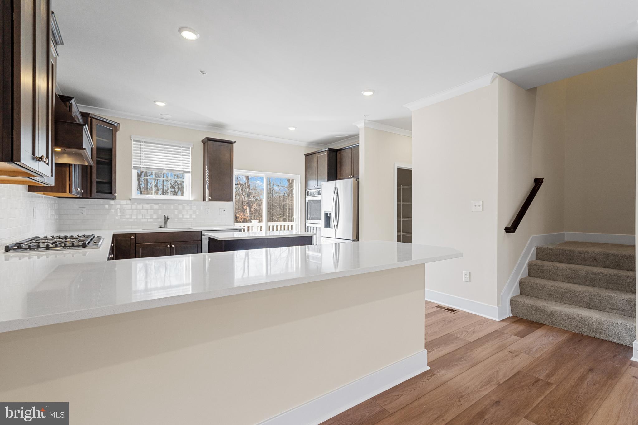 1730 Water Xing Road Baltimore, MD 21208 - Photo 10 of 33 a large kitchen with stainless steel appliances granite countertop a large counter top a stove and a wooden floors
