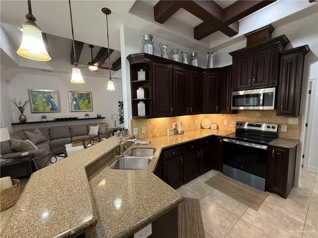 a kitchen with a sink a counter space appliances and cabinets