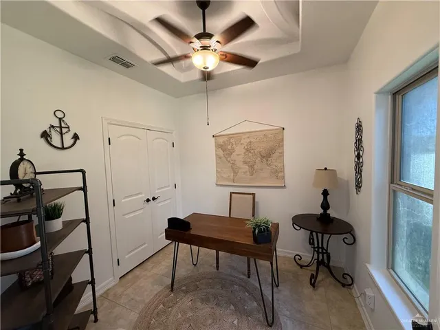 a view of a workspace with furniture and a window