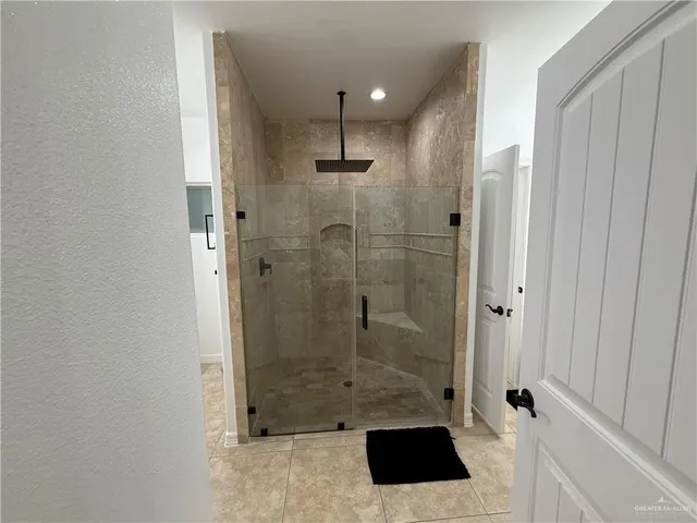 a view of a hallway with wooden floor and a bathroom
