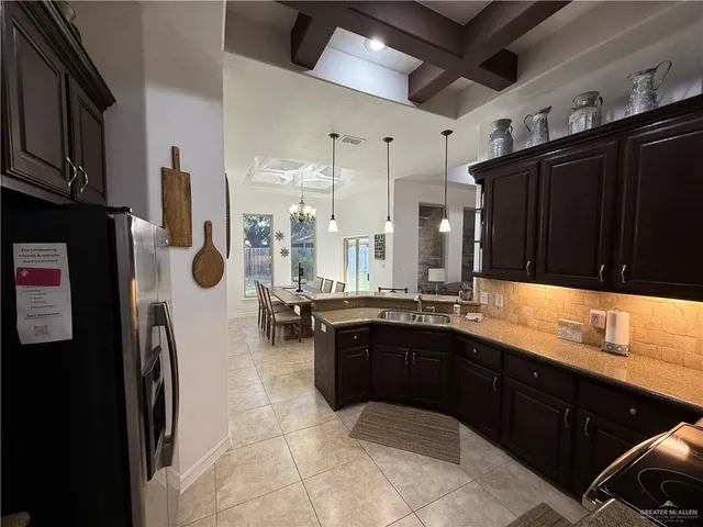 a large kitchen with a sink and refrigerator