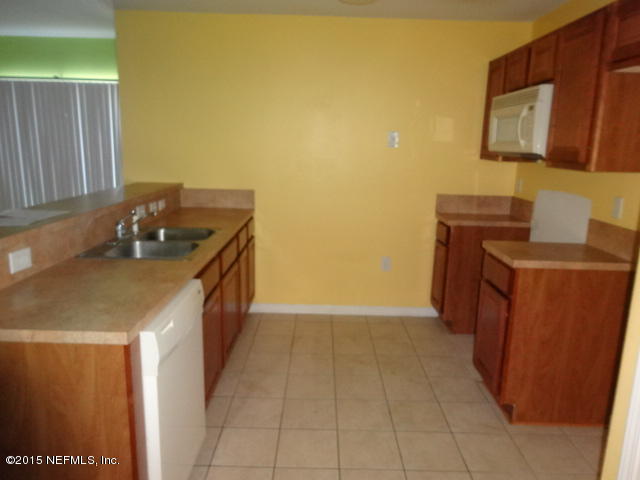 7920 Merrill Road, Unit 1013 Jacksonville, FL 32277 - Photo 3 of 11 a kitchen with a sink and a stove top oven