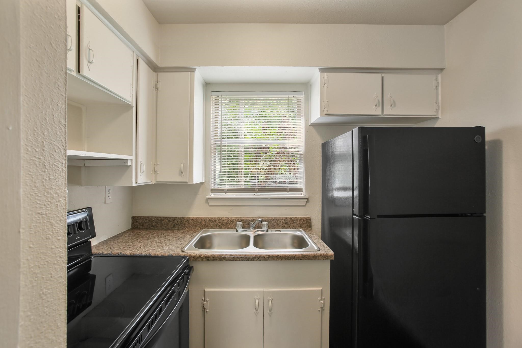 5415 3 Rd Street, Unit 1 Danbury, TX 77534 - Photo 2 of 8 a kitchen with a refrigerator sink and cabinets